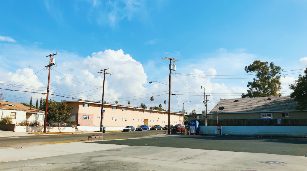 A photograph of a gas station parking lot in a residential neighborhood